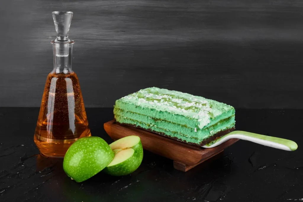 slice-green-cake-with-bottle-cognac