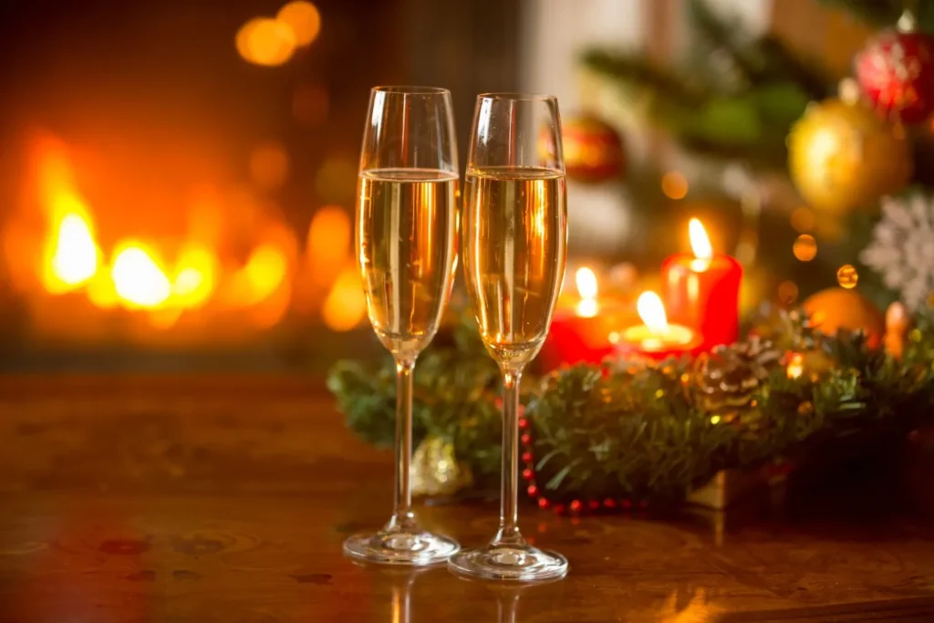 beautiful-new year-background-with-white wine-flutes-burning-fireplace-with-candles