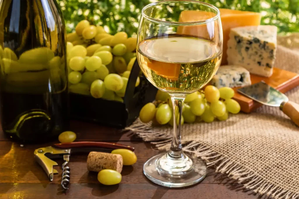 white wine on table with cheese grapes