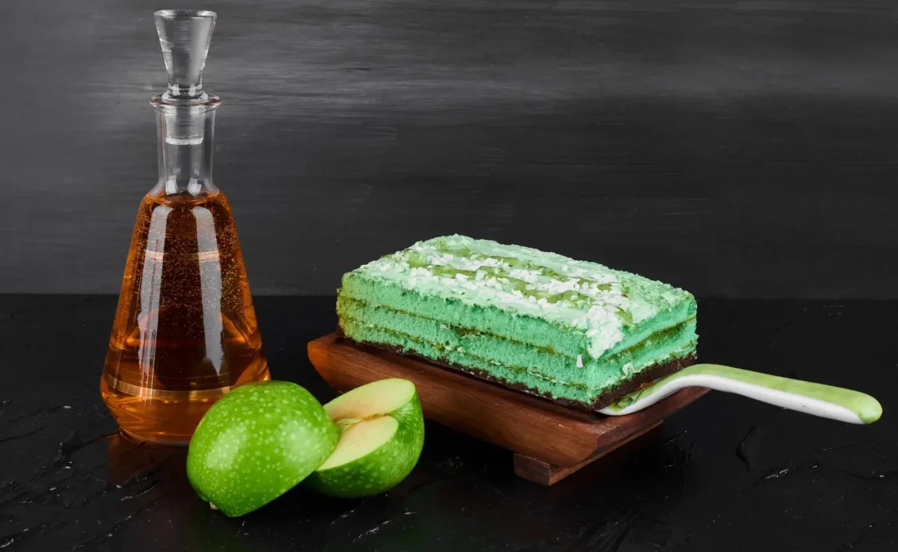 slice-green-cake-with-bottle-cognac